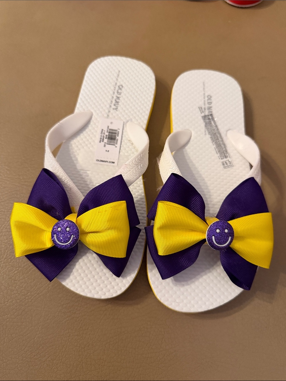 Old Navy White Flip Flops with Purple & Yellow Bow Smiley Accents